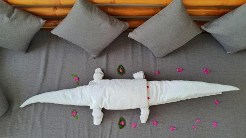 a white stuffed animal on a bed with pink flower petals at Hoi An Rustic Villa in Hoi An