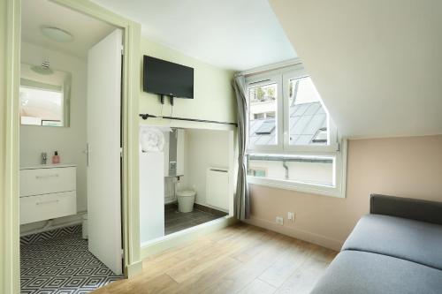 un salon avec un canapé et une fenêtre dans l'établissement Rent a Room - Cosy studio, à Paris