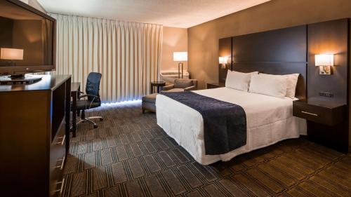 a hotel room with a bed and a flat screen tv at Best Western Andersen's Inn in Santa Nella Village