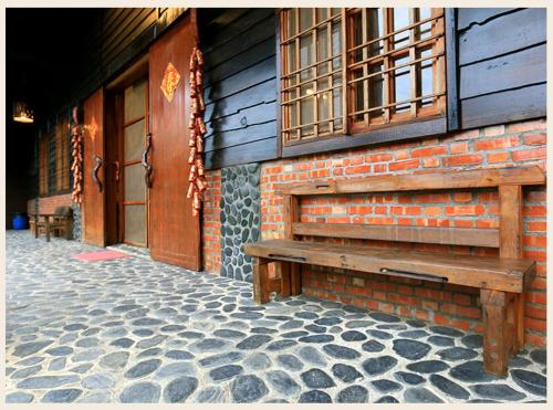 a wooden bench sitting outside of a brick building at 初鹿敦親牧鄰民宿 in Chulu