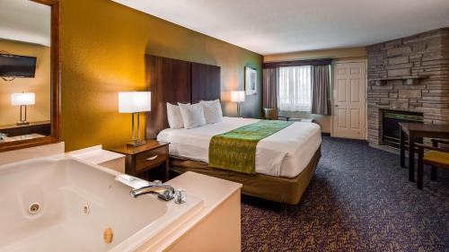 a hotel room with a bed and a bath tub at Best Western Plaza Inn in Pigeon Forge