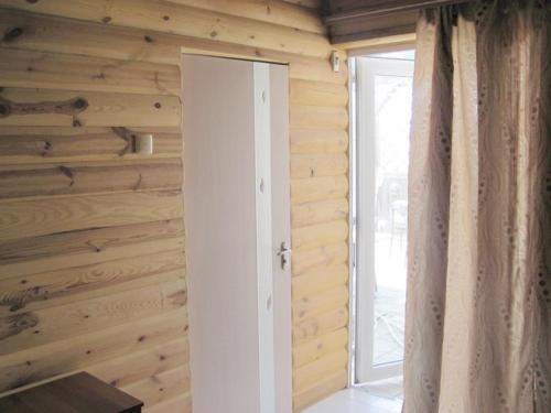 ベルジャーンシクにあるOtdyh - Berdyanskaya Kosaの木製の壁、ドア、窓が備わる客室です。