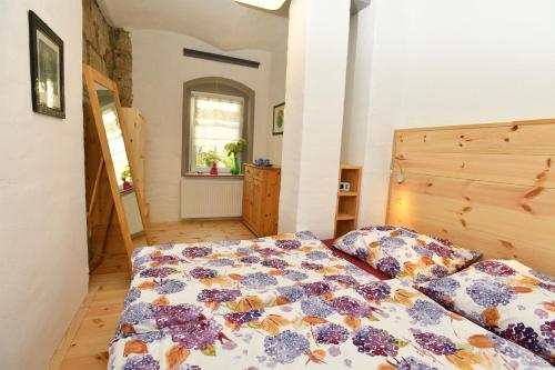 a bedroom with a bed with a colorful comforter at Hortensiensuite in Pirna