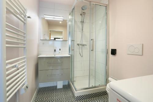 une salle de bain avec une douche en verre et un lavabo dans l'établissement Rent a Room - Chenier Paradise, à Paris