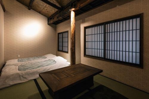 ein kleines Schlafzimmer mit einem Bett und einem Fenster in der Unterkunft Hazuki Kyoto in Kyoto