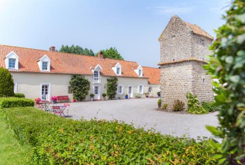 a view of a house with a stone tower at Le Colombier in Wissant