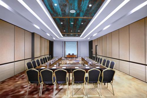a conference room with a long table and chairs at The Alts Hotel in Palembang