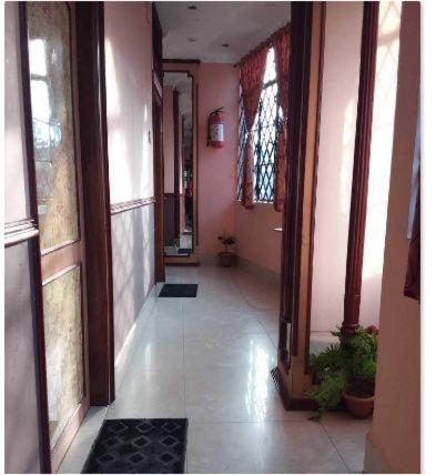 einen Flur eines Hauses mit rosa Wänden und einem Flur sidx sidx sidx in der Unterkunft Hotel City Hub in Shillong