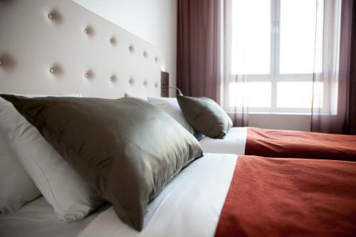 a bedroom with two beds with pillows and a window at Best Western Hotel River C in Karlstad