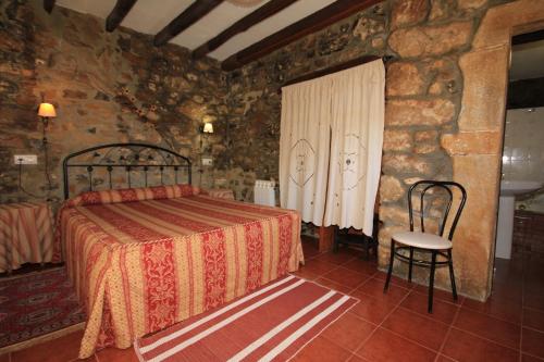 1 dormitorio con 1 cama en una habitación de piedra en La Llosa II, en Villaviciosa