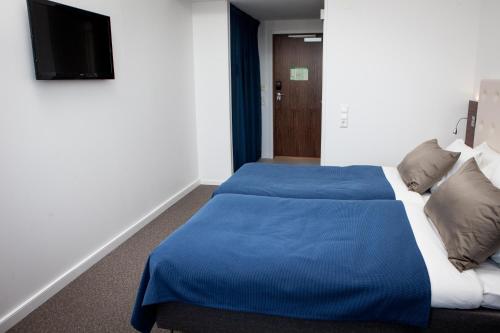 a bedroom with a bed with a blue blanket at Best Western Hotel River C in Karlstad