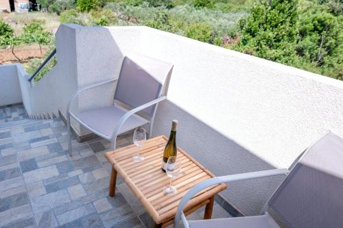 a bottle of wine sitting on a table with two chairs at Apartments Marković in Stari Grad