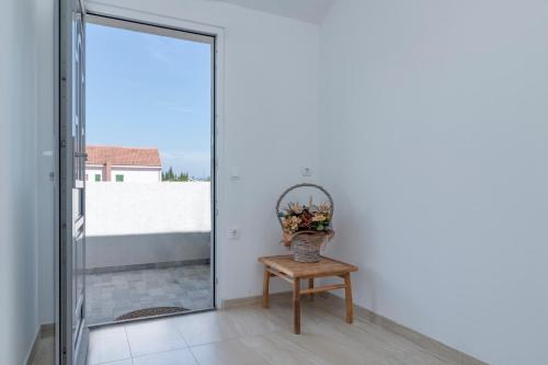 a glass door leading to a balcony with a vase of flowers at Apartments Marković in Stari Grad
