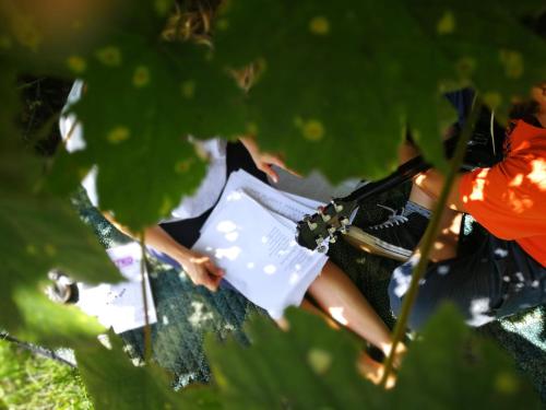 a woman sitting on the ground holding a book at Alloggio del Fiume - Le Vecchie Vasche in Scoppito
