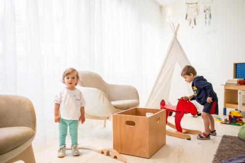 two children playing in a living room with a box at Hotel Solemare in Milano Marittima