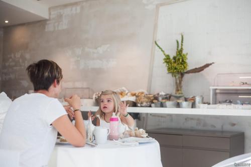 a man and a little girl sitting at a table at Hotel Solemare in Milano Marittima