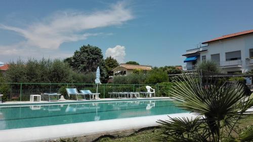 una piscina con 2 sillas y una mesa en Appartamenti Calicante, en Bardolino