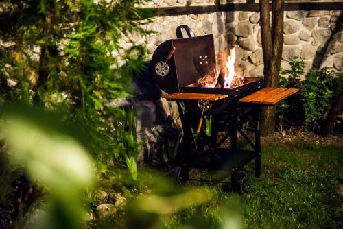 a grill with a fire in it in a yard at Banskovilla Zlateva House in Bansko