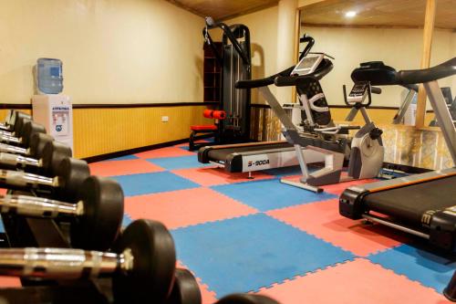 a gym with several treadmills and exercise bikes at Hotel Duomo and Suites in Kampala