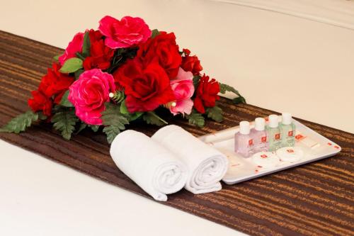 a table with towels and a bouquet of red roses at New York Hotel in Johor Bahru