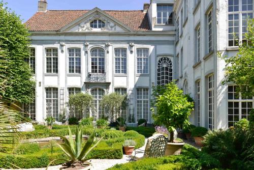 a large white building with a garden in front of it at B&B The Verhaegen in Ghent