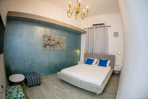 a bedroom with a bed and a blue wall at Eshel Mansion - Boutique Suites in Beer Sheva