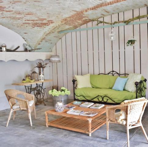un soggiorno con divano verde e tavolo di Tenuta Ajrale a Vigone