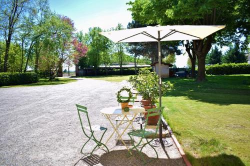 a table and chairs with an umbrella in a yard at Tenuta Ajrale in Vigone
