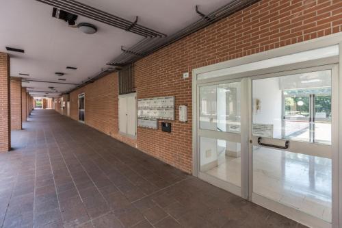 um corredor vazio com uma porta num edifício de tijolos em Dossetti, Bologna by Short Holidays em Bolonha