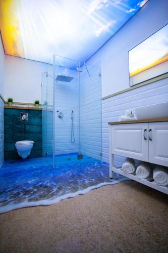 a bathroom with a glass shower and a sink at Eshel Mansion - Boutique Suites in Beer Sheva