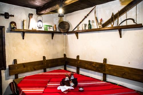 a room with a red bed with two dolls on it at Banskovilla Zlateva House in Bansko