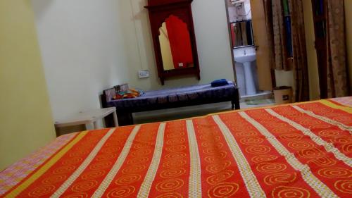 a bedroom with a bed and a bench in a room at Shivam Tourist Guest House in Būndi