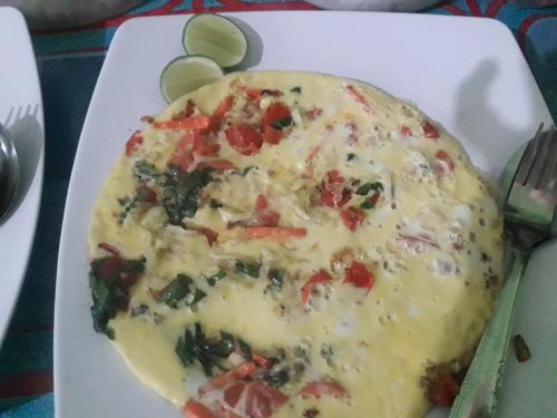 セコトンにあるPelangi Homestay Bungalow Gili gedeのチーズと野菜のピザが載った白い皿