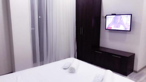 a bathroom with a tv on a wall with a sink at Wonderland in Chakvi