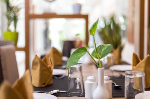 a table with a vase with a plant on it at Sugar Business Hotel in Cochin