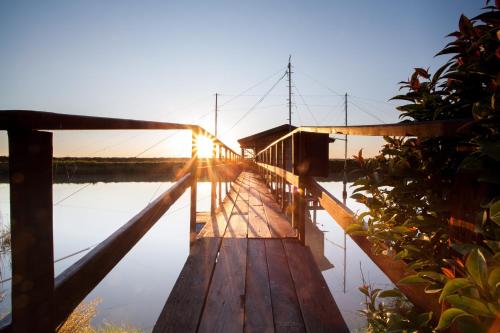 a bridge over a body of water with the sun setting at Hotel Majestic in Milano Marittima