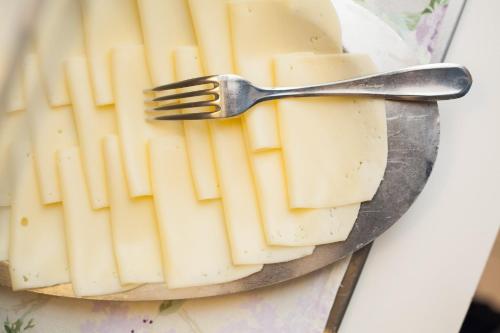 a plate of cheese with a fork on it at Hotel Majestic in Milano Marittima