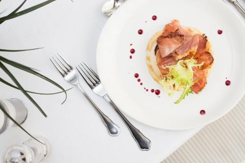 a plate of food with meat and broccoli on a table at Hotel Majestic in Milano Marittima