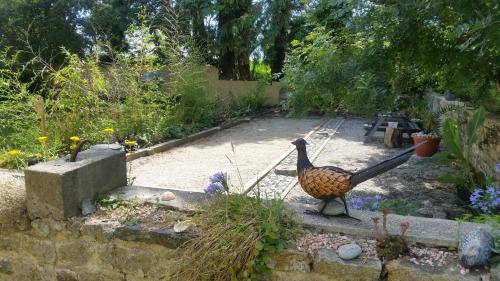 a statue of a bird in a garden at L'Effraie des Clochers in Cast