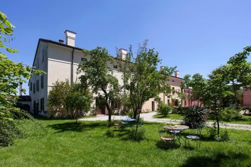 a yard with chairs and tables in front of a building at Corte Mainolda in Castellucchio