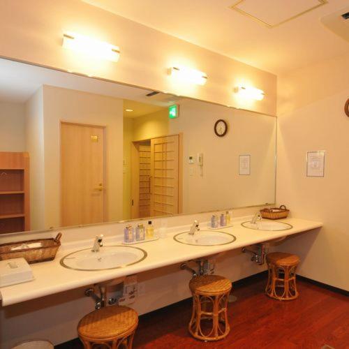 a bathroom with two sinks and a large mirror at Grand Park Hotel Odate in Odate