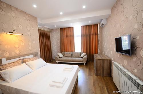 a hotel room with a bed and a couch at Dream Tower in Batumi