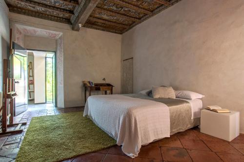 una camera con un grande letto e un tappeto verde di Corte Mainolda a Castellucchio
