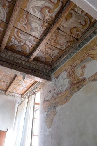 a room with a ceiling with paintings on it at Corte Mainolda in Castellucchio