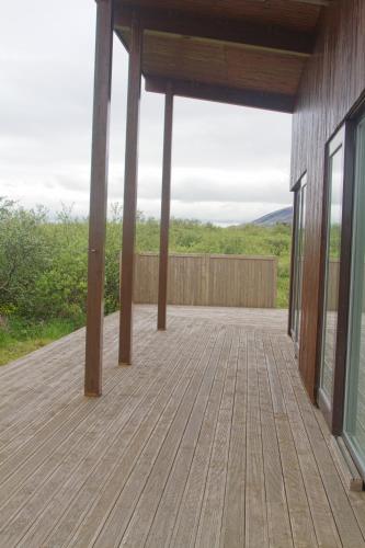 a porch of a house with a wooden deck at Luxury Cottage, Golden Circle HG-4618 in Úlfljótsvatn