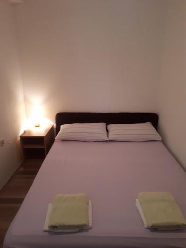 a bedroom with a white bed with two towels on it at Apartman Miro in Cavtat