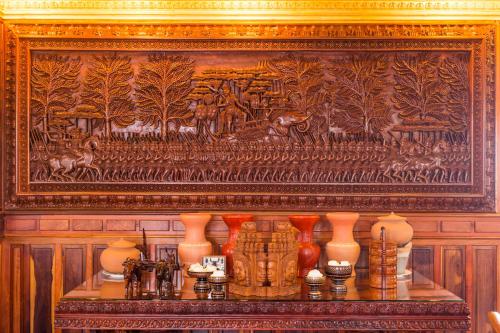 a painting on a wall with vases on a table at Okay Boutique Hotel in Phnom Penh