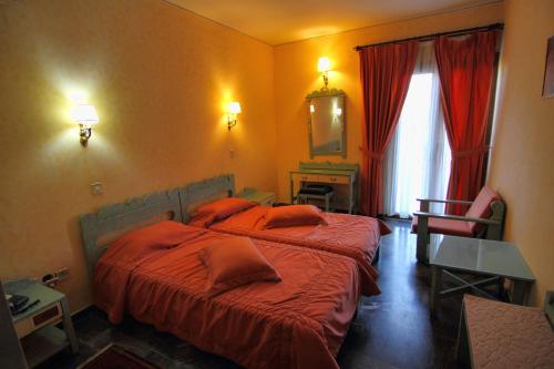 A bed or beds in a room at Mytilana Village Hotel