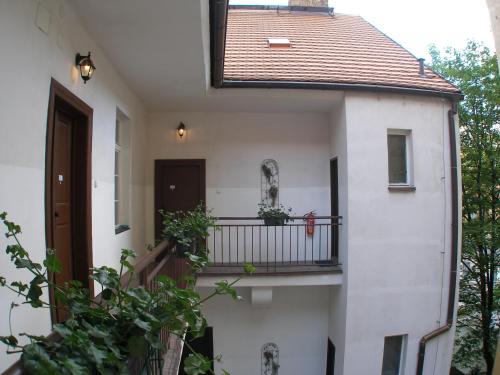 プラハにあるMila Apartmentsの白い家の外の景色を望むバルコニー付