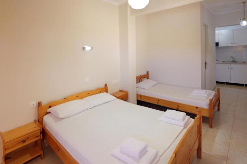 two twin beds in a room with a kitchen at Panorama Plataria Ionio Studios&Apartments in Plataria